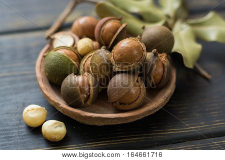 Macadamia nuts in shell on wooden table