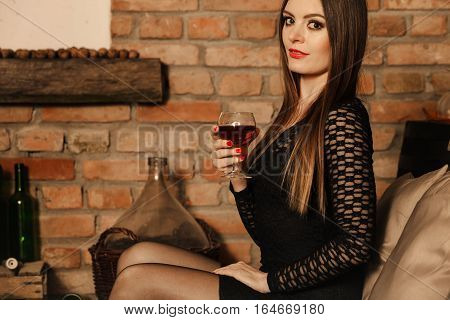 Woman Tasting Wine In Rural Cottage Interior