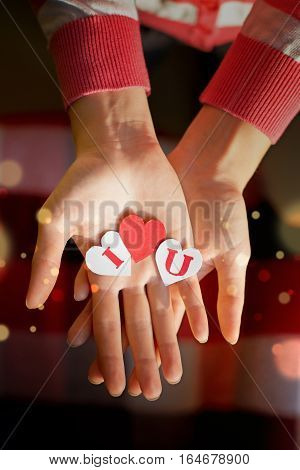 Paper hearts with letters in the girl's hands. A Declaration of love