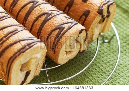 Sweet swiss rolls (roulade) with white cream on green tablecloth