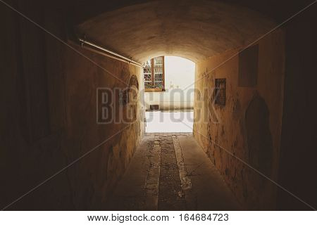 Small dark tunnel. Aged walls with cracked paint. Way to the light.