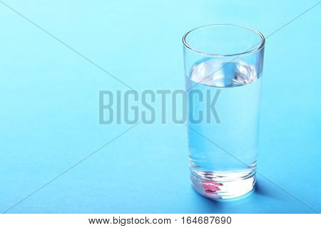Glass with water on a blue background