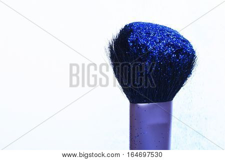 soft cosmetics brush with blue sparkle glister isolated on white copy space