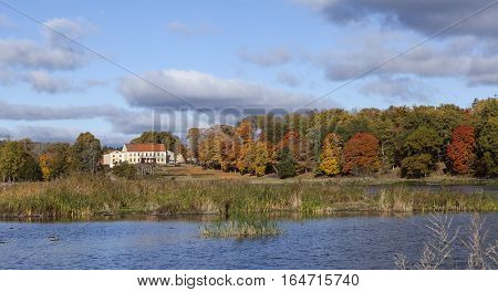 ROSLAGEN, SWEDEN ON OCTOBER 10. View in the morning, colorful leaves in the trees, a sunny estate on October 10, 2016 in Roslagen, Sweden. Lake this side. Editorial use.