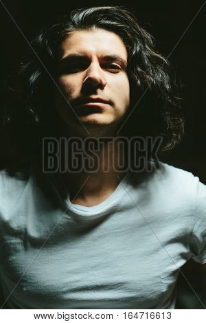 Portrait of a handsome young man with long hair close-up