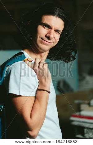 Successful young handsome guy with a denim jacket over his shoulder