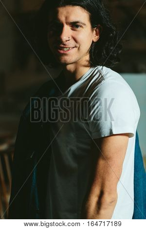 Successful young handsome guy with a denim jacket over his shoulder