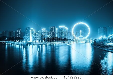 night view of haihe river and ferris wheel in tianjin blue tone