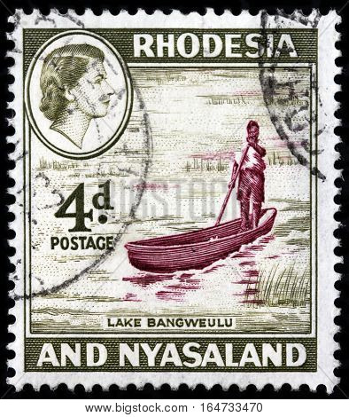LUGA RUSSIA - SEPTEMBER 18 2015: A stamp printed by RHODESIA AND NYASALAND shows image portrait of Queen Elizabeth II against view of Bangweulu Lake 1959