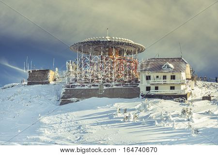 Buildings on Postavarul mountain top in the Romanian ski resort Poiana Brasov. The Postavarul peak covered by snow in the winter season.