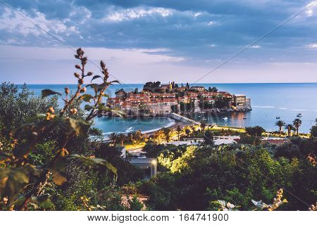 Sveti Stefan island - popular tourist attraction near Budva, Montenegro. Evening view of Adriatic sea coast and St. Stefan luxury fortificated village by lights.