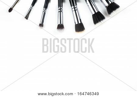 Makeup brushes lying on a white background