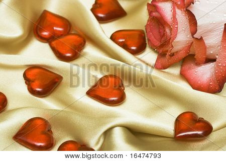 red rose on satin with hearts