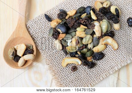 mixed nuts on wooden table with wood spoon