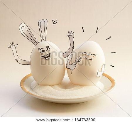 Two funny eggs on a saucer smiling. Happy Easter