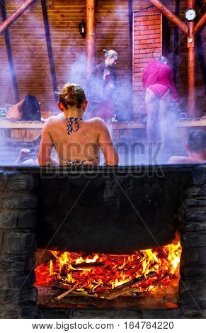 Lumshory Ukraine - January 10 2017: A woman bathes in a the cast iron vat with mineral water containing hydrogen sulphide. Water in cast iron vats heated to 40-45 degrees Celsius.