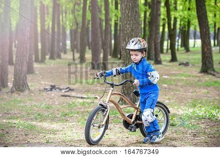 Happy Cute Blond Kid Boy Having Fun His First Bike On Sunny Summer Day, Outdoors.  Child Making Spor