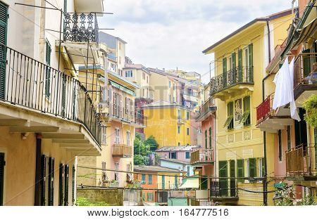 Manarola town Riomaggiore La Spezia province Liguria northern Italy. View of the colourful houses on surrounding hills balconies and windows. Part of the Cinque Terre National Park and a UNESCO World Heritage Site.