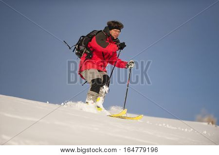 Alpine skier. Mid adult man skiing down steep hill in nature.