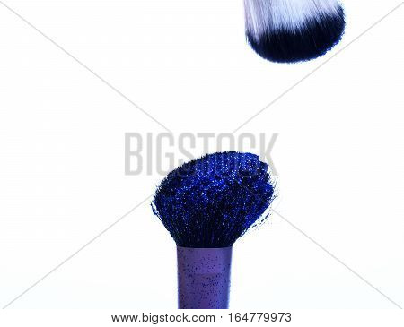 soft cosmetics brushes with blue sparkle glister isolated on white copy space