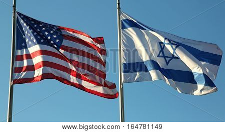 American And Israeli Flags Waving In The Blue Sky