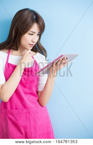 beauty housewife take tablet and smile isolated on blue background asian