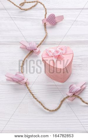 Valentine's day concept. -Pink heart shape gift box and hearts on clothes line