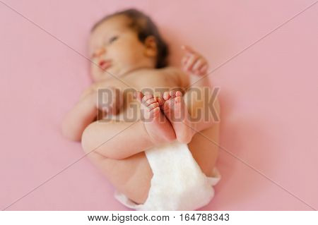 Close up of newborn baby's feet, soft focus on rest of baby