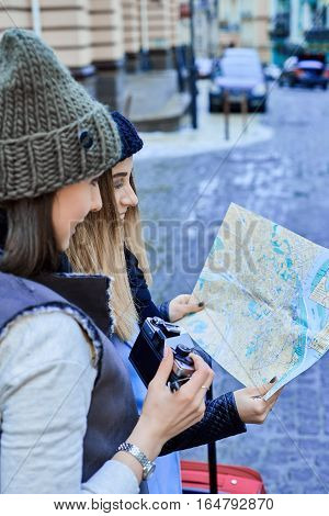 Two friends tourists choose attractions on the paper map
