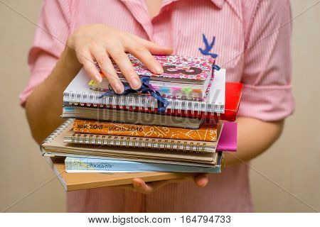 Stack of notebooks in the hands. Sketchbooks