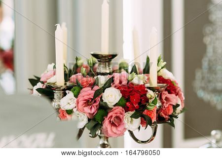 Colorful flowers and white candles in the room
