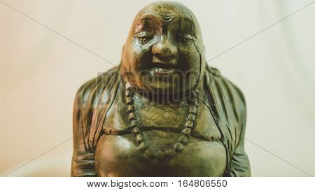 wooden statue laughing Buddha. The character of Chinese Buddhism