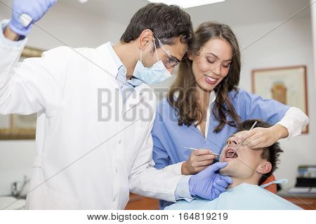 Young Man Having Dental Chekup At Dentist Office