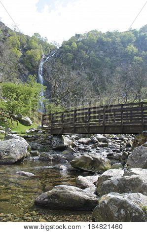 Aber Falls Bridge with river bellow and waterfall in the background,  Abergwyngregyn North Wales UK