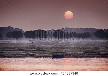 The sun rises over the eastern riverbank of the Ganges River near Varanasi India.