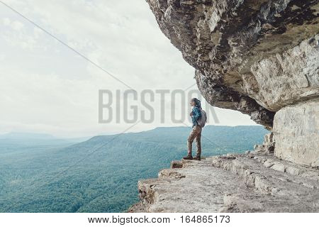 Backpacker young woman standing on cliff Eagle shelf and enjoying view of nature Mezmay Krasnodar region Russia
