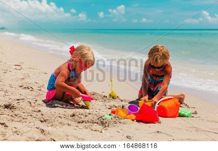 kids play with sand on summer tropical beach