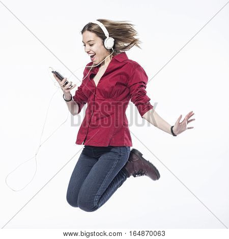 Happy girl jumping with headphones over white background