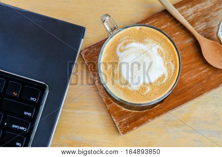 coffee cup on wood table with labtop office space
