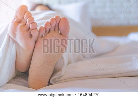 Close up feet of women sleeping women on bed