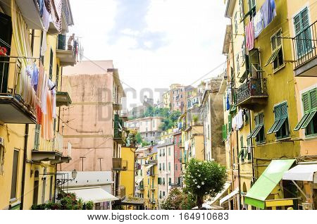 Riomaggiore village La Spezia province Liguria northern Italy. View of the colourful houses on steep hills the castle with clock laundry on balconies. Part of the Cinque Terre National Park and a UNESCO World Heritage Site.