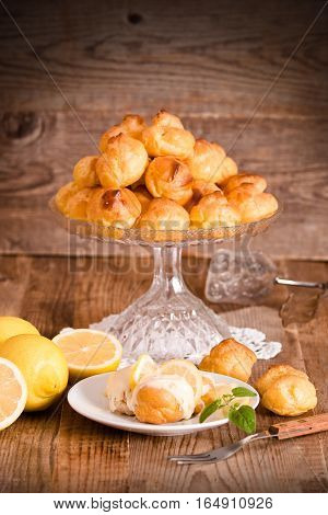 Lemon Profiteroles with custard cream on white dish.