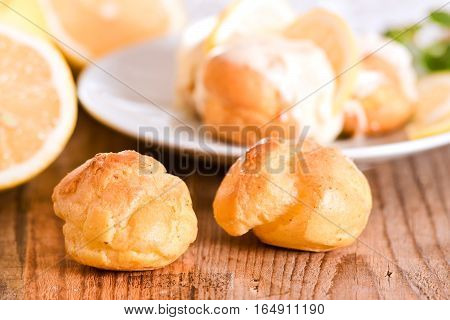 Lemon Profiteroles with custard cream on white dish.