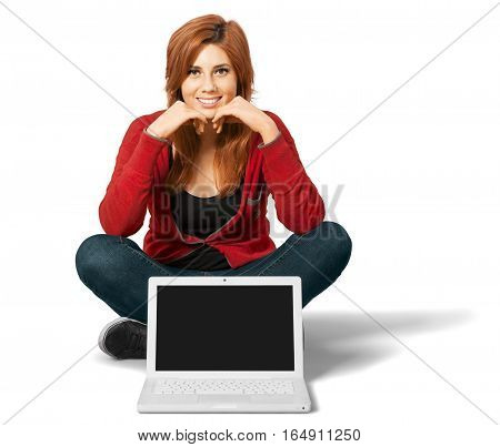 Red headed woman sitting crosslegged with an open laptop in front of her