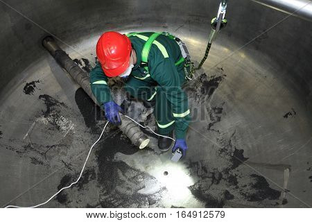 St. Petersburg Russia - August 9 2016: Internal industrial boiler inspection the worker is inside the boiler during its repair.