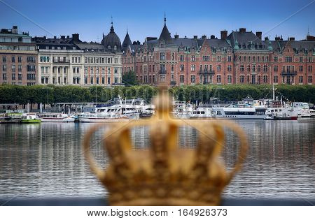 STOCKHOLM SWEDEN - AUGUST 20 2016: Skeppsholmsbron (Skeppsholm Bridge) with Golden Crown on a bridge and view on Ostermalm with sightseeng boats in Stockholm Sweden on August 20 2016.