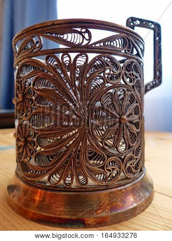 Cup holder. Cupronickel, tracery pattern. Closeup. Retro.