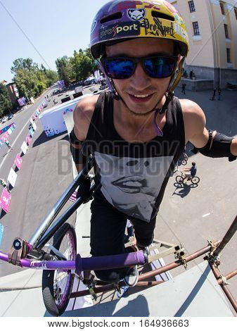 KAZAKHSTAN ALMATY - AUGUST 28, 2016: Urban extreme competition, where the city athletes compete in the disciplines: skateboard, roller skates, BMX. Bmx stunt performed at the top of a mini ramp on a skatepark.