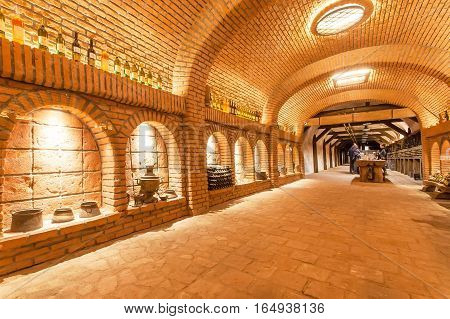 KVARELI, GEORGIA - OCT 3, 2016: Old grape wine cellar Khareba Winery with many bottles in unique underground tunnel on October 3, 2016. The tunnel was opened in 1962 for the World Wine Congress