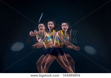 Portrait of beautiful girl tennis player with a racket on dark studio background. Stroboscope shooting technique